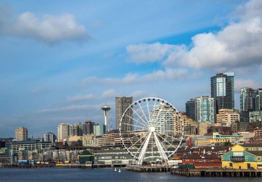 Seattle waterfront ve manzarası, Space Needle gösteren büyük tekerlek dönme dolap ön planda konuşmacı aracılığıyla ile. Geç öğleden sonra altın ışık ile renkli görüntü.