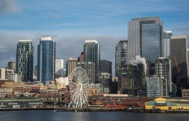 Seattle waterfront ve manzarası, Space Needle gösteren büyük tekerlek dönme dolap ön planda konuşmacı aracılığıyla ile. Geç öğleden sonra altın ışık ile renkli görüntü.