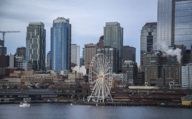 Seattle waterfront ve manzarası, Space Needle gösteren büyük tekerlek dönme dolap ön planda konuşmacı aracılığıyla ile. Geç öğleden sonra altın ışık ile renkli görüntü.