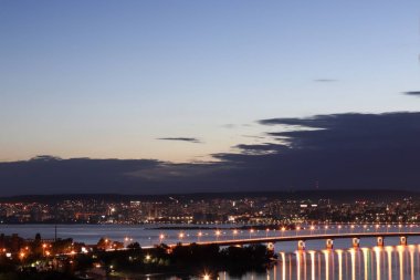 Volga Nehri'nin karşı kıyısından Saratov şehrinin yüksekliği görünümü. Saratov Köprüsü. Yaz alacakaranlık. Rusya, Saratov ve Engels şehri.