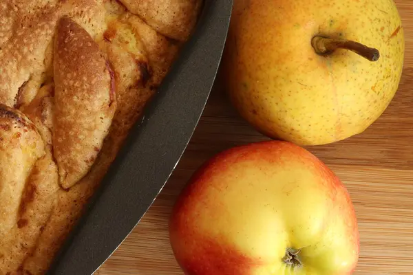 自制的苹果派放在烤盘上 梨子和苹果放在木制桌子上 夏洛特派 从上面看 — 图库照片