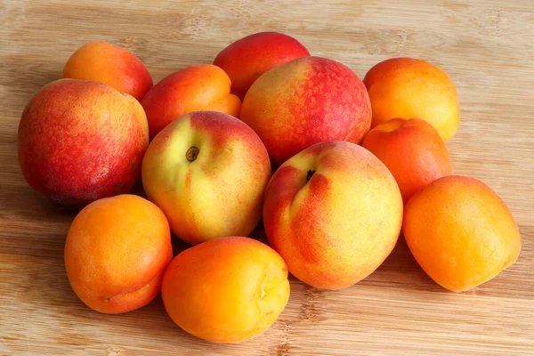 Renkli yaz meyveleri yığını. Ahşap arka planda kayısı ve şeftali..