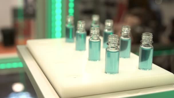 Роботизированная Рука Устанавливает Фармацевтические Бутылки Голубой Жидкостью После Производства Автоматическое — стоковое видео