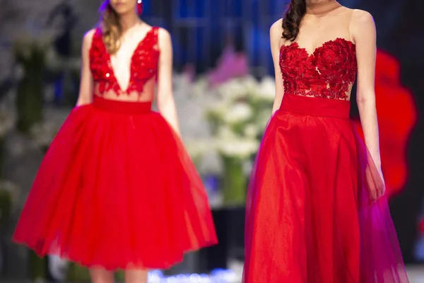 女性モデルは ファッションショー中に赤いドレスで滑走路を歩く 新しい服のコレクションを示すファッション キャットウォーク イベント — ストック写真