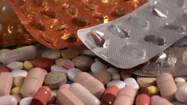 不同的五颜六色的胶囊和药丸在前面使用的空包 全球医药行业每年数十亿美元 用作药物的药物 — 图库视频影像