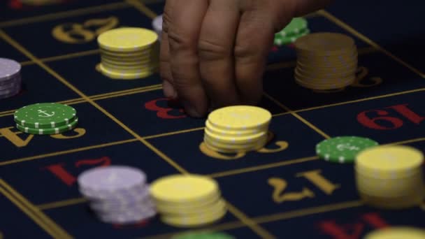 轮盘赌桌子与人的手放下筹码在赌场 轮盘赌在前景 赌博游戏 无法辨认的人 — 图库视频影像