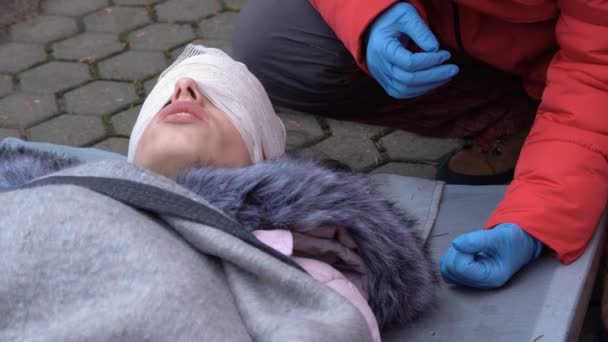 Volunteer paramedics from Bulgarian Red Cross Youth bandages head bandage during a training for saving people in an accident. — Stock Footage Volunteer Paramedics Bulgarian Red Cross Youth Bandages Head Bandage Training Stock Footage