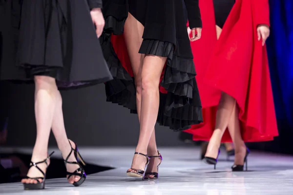 女性モデルは ファッションショー中に別のドレスで滑走路を歩く 新しいコレクションの服を示すファッションキャットウォークイベント 足と靴のみ — ストック写真