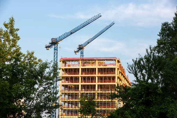 Edificio Sin Terminar Con Dos Grúas Árboles Primer Plano — Foto de Stock