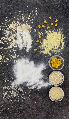 Yulaf ezmesi ve yulaf ezmesi, mısır unu ve mısır gevreği, pirinç unu ve siyah desenli arka planda pirinç..