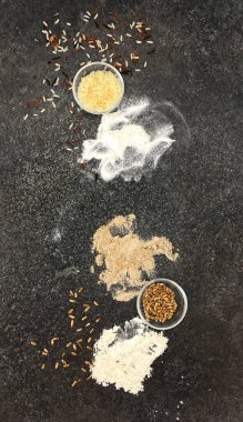 Tahıl ve un, çeşitli tahıl ve un türleri siyah desenli bir taşın üzerinde. Pirinç, buğday, pirinç, buğday ve çavdar unu. Yukarıdan görüntüle