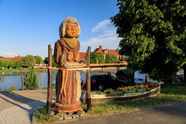 Malbork, Polonya - 02 Haziran 2018: Yaşlı kadın Malbork Cermen kalede arka plan üzerinde ahşap heykel