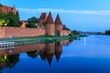 Saat akşam Malbork Cermen Castle suya yansıyan