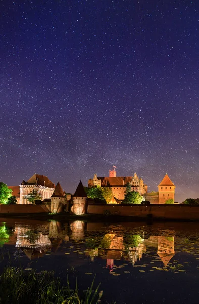 stock image Teutonic Castle of Malbork under starry sky at night