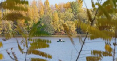 Sonbahar nehirde bir teknede balıkçı