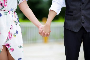 Çift, gün batımında el ele tutuşur..