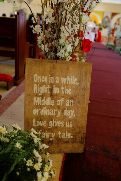 Church wedding interior with rows of elegant chairs and flowing flower arrangements.