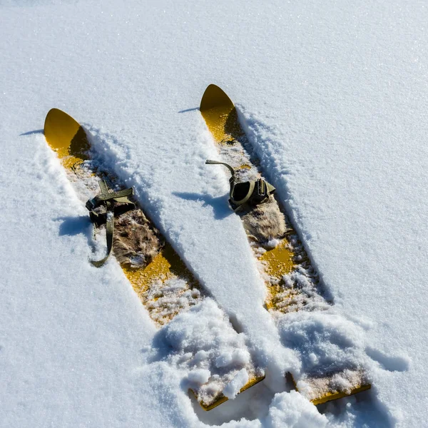 白色雪地上的老式木制黄色滑雪板 冬季背景 — 图库照片