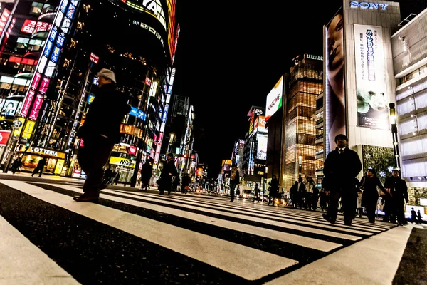 東京都 2010年1月14日東京 銀座の中心街を横断する歩行者 夜の銀座交差点 ぼやけた動き 穀物効果 — ストック写真