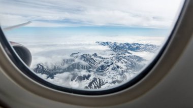 Beautiful view of the Kamchatka mountains from the airplane porthole. clipart