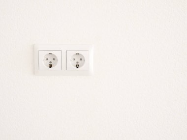 Duvarda modern beyaz çift soket var. Ev yapımı elektrikli ekipman.