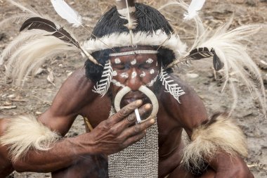 Wamena, Endonezya - 9 Ocak 2010: Dugum Dani Köyü 'nde sigara içen geleneksel bir elbise içindeki Dani kabilesinin lideri. Baliem Vadisi Papua, Irian Jaya, Endonezya Yeni Gine