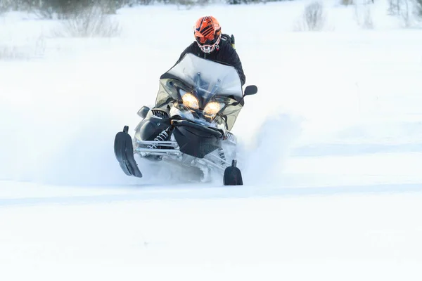 Teriberka, Rússia - 24 de fevereiro de 2018: Homem de capacete esportivo monta uma moto de neve — Fotografia de Stock