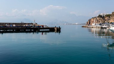 Antalya, Türkiye - 22 Şubat 2019: Antalya 'daki Eski Kaleici Kasabası' nın limanında deniz feneri yakınlarında balık tutan iki balıkçı.