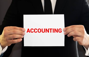 Hesap makinesi ve odaklanmamış ön planda kalemle sarı bir klasöre yazı yazmak. Beyaz parlak arka plan. Muhasebe ve iş konsepti