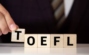 TOEFL - harfli tahta bloklardan kelimeler, İngilizce yabancı dil testi, TOEFL konsepti, beyaz arkaplan.