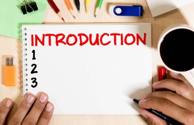 Tanıştırayım. Kağıt üzerinde mesaj var. Eski ahşap masa üstünde akıllı telefon, kalem, ataç.