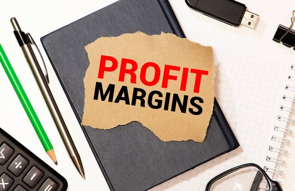 PROFIT MARGIN , on the tablet pc screen held by businessman hands - online, top view.