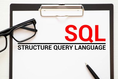 SQL ile yazılmış klavye, çöp kağıdı, pano, kalem ve kağıt üst görünümü
