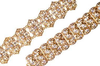 Pırlantalı beyaz bir arka plan üzerinde iki altın bilezik