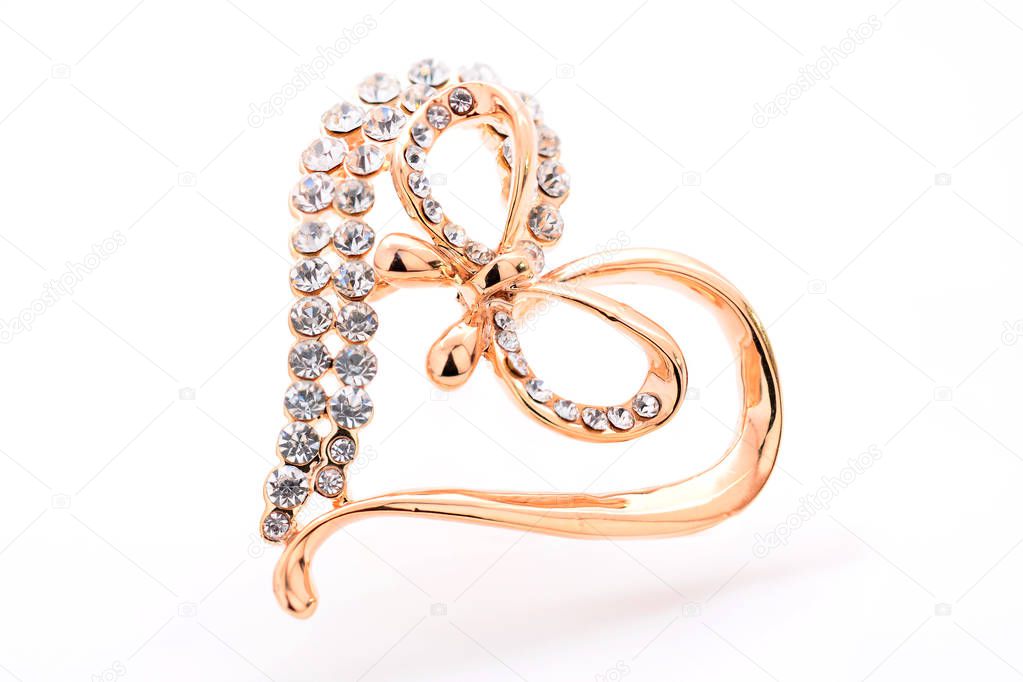 gold brooch heart with diamonds and bow isolated on white