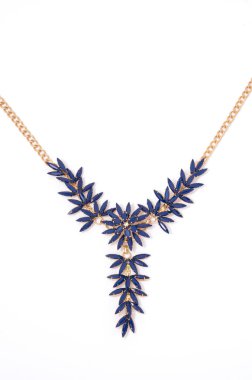 Beyaz arka plan yakın çekim üzerinde mavi çiçekli altın kolye