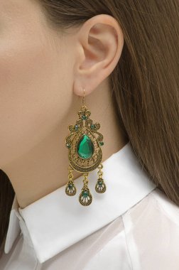 earring with emerald on the woman's ear clipart