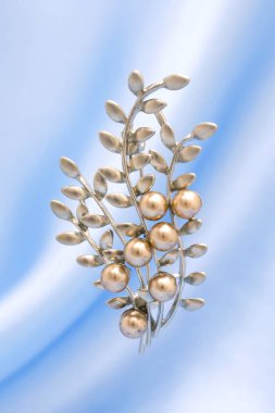 silver brooch twig with pearls isolated on silk clipart