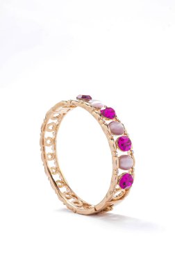 Beyaz arka plan üzerinde pembe taşlarla altın bilezik