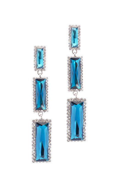 Blue earrings inlaid with precious stones on a white background