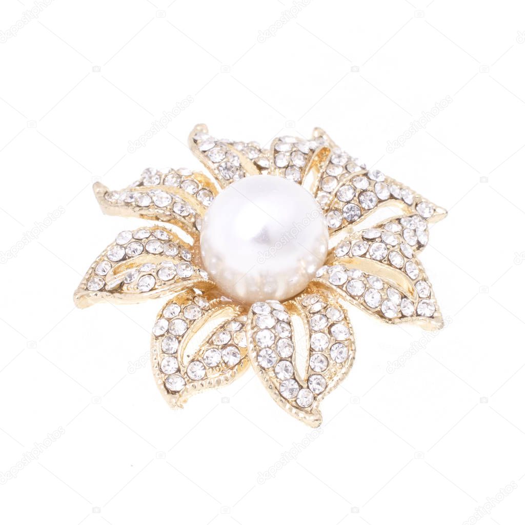 gold brooch flower with a pearl and gems isolated on white