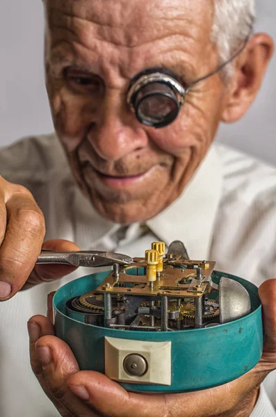 old watchmaker repairing clocks