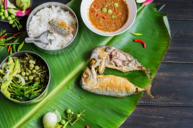 Kızarmış uskumru ve karides ezmesi sosu ve sebze. Tahta bir masada Tayland yemeği.