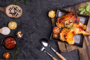 Pişirilmiş ya da ızgara tavuk kanadı. Şefin, kaşıklar ve baharatlarla titizlikle iştah açıcı pişirdiği ve siyah bir masaya servis edilmeye hazır olduğu yer..