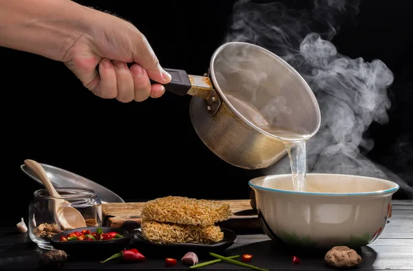 Şef, ahşap bir masa üzerinde acı biberli ve limonlu Shiitake soslu sıcak çorba eriştesi hazırlıyor..