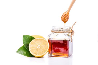 Limonlu doğal bal beyaz bir arka plana yerleştirilmiş. Limonlu bal içme kavramı