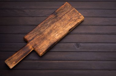 Eski antika mutfak aletleri eski siyah ahşap zemin manzarasına yerleştirilmiş kesme tahtaları.