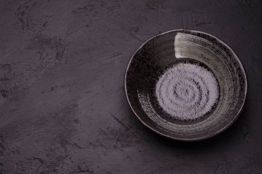 Siyah zemin üzerinde boş siyah çorba tabağı, üst görünüm