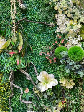 Duvarlar güzel bir şekilde suni ot ve çiçeklerle süslenmiş..