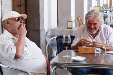 Madrid, İspanya - 24 Ağustos 2016 İspanya 'nın başkentinde güneşli bir günde iki erkek bir barın önünde sosyalleşiyor